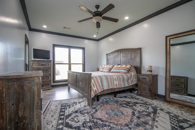 bedroom featuring visible vents, crown molding, and wood finished floors