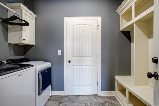 clothes washing area with cabinet space, independent washer and dryer, and baseboards