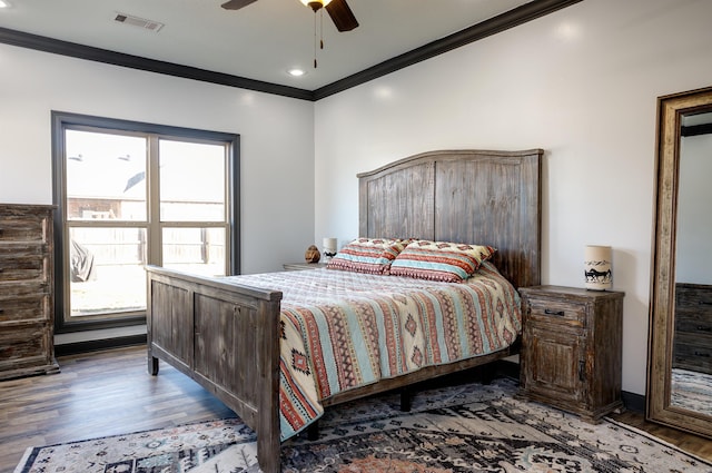 bedroom featuring ceiling fan, ornamental molding, wood finished floors, and visible vents