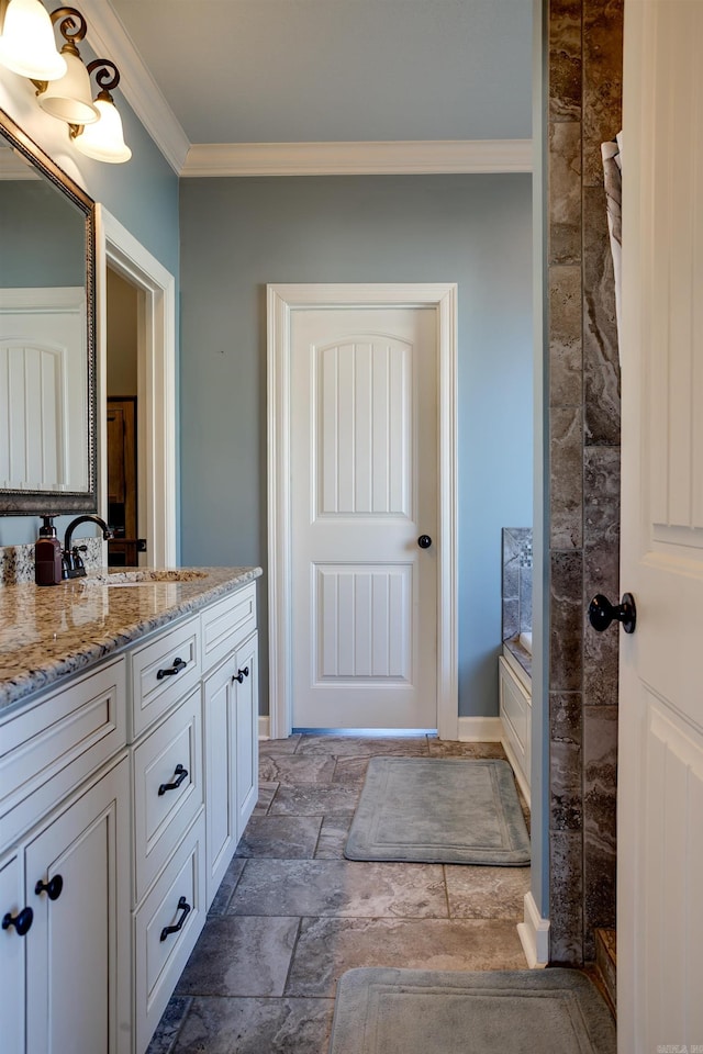 full bath with a tub to relax in, ornamental molding, stone finish floor, vanity, and baseboards