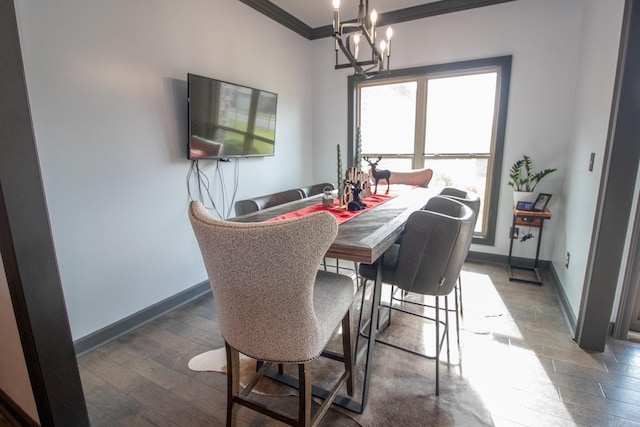 dining space featuring ornamental molding, a chandelier, baseboards, and wood finished floors