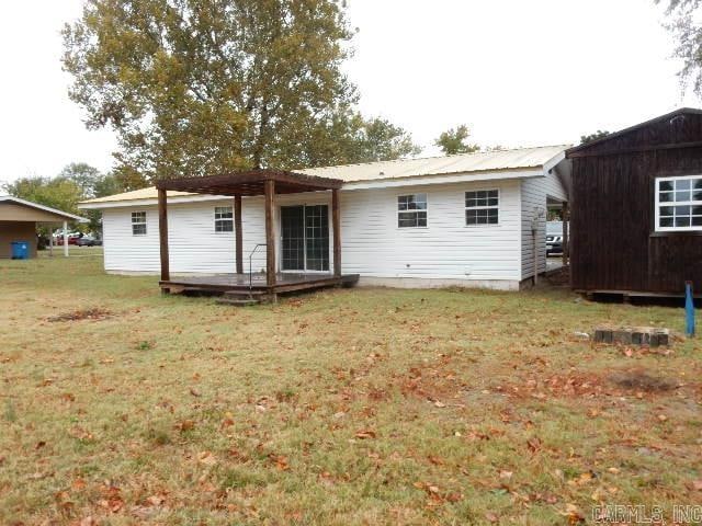 rear view of house featuring a lawn, a shed, and a deck