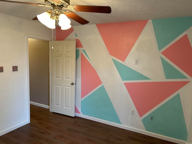 interior space featuring a textured ceiling, ceiling fan, and dark wood-type flooring