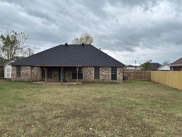 back of property with central AC, a yard, and a patio