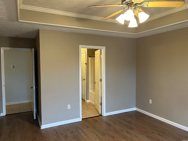 unfurnished bedroom featuring wood-type flooring, a textured ceiling, ceiling fan, and crown molding