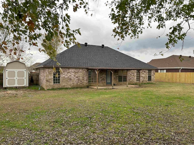 back of house with a yard, a patio, and a storage unit