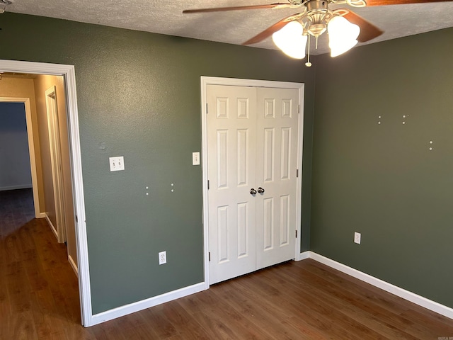 unfurnished bedroom with a closet, ceiling fan, hardwood / wood-style floors, and a textured ceiling