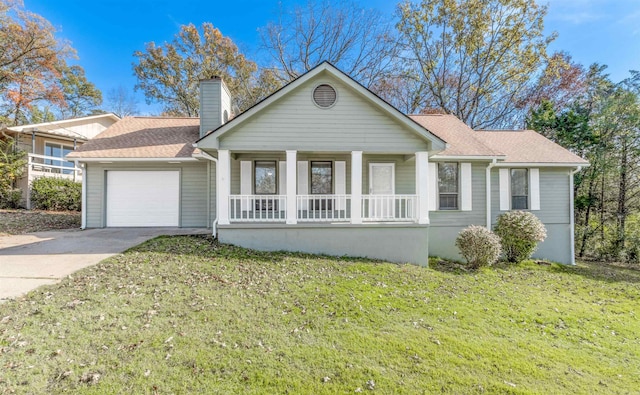 view of front of home featuring covered porch, a garage, and a front lawn