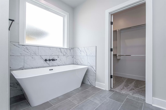 bathroom with a bathtub and tile walls