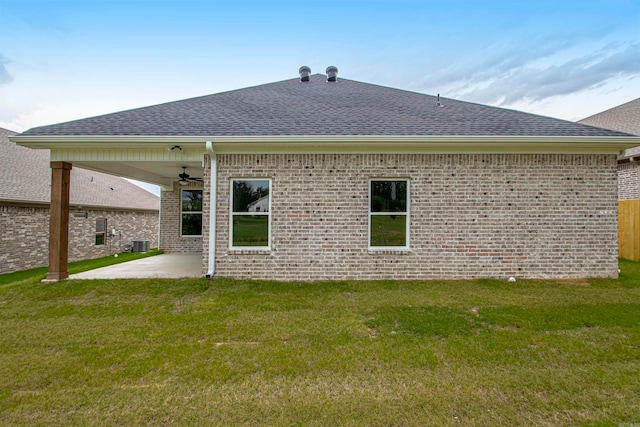 rear view of house featuring a yard, ceiling fan, a patio area, and central air condition unit