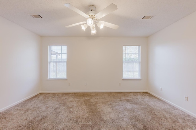 empty room with light carpet, a textured ceiling, and ceiling fan