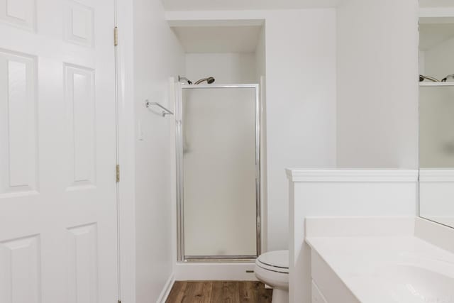 bathroom featuring toilet, hardwood / wood-style floors, vanity, and walk in shower