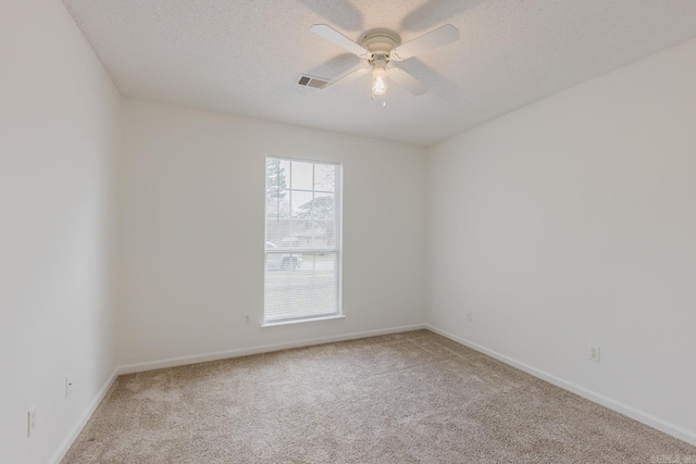 unfurnished room featuring a textured ceiling, light colored carpet, and ceiling fan