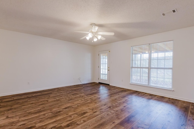 empty room featuring a textured ceiling, dark hardwood / wood-style floors, and ceiling fan