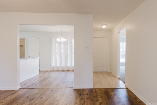 entryway with light hardwood / wood-style flooring and a notable chandelier