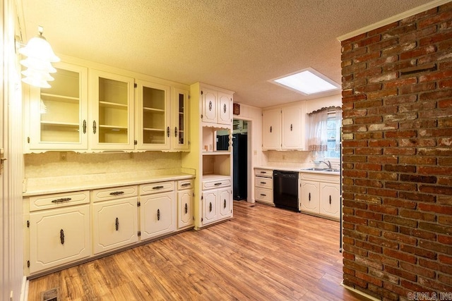 713 N Spring St, Searcy, AR 72143 - kitchen with dishwasher, a textured ceiling, light countertops, light wood-style flooring, and glass insert cabinets