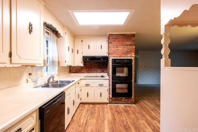 713 N Spring St, Searcy, AR 72143 - kitchen featuring black appliances, a sink, under cabinet range hood, light wood-style flooring, and white cabinetry