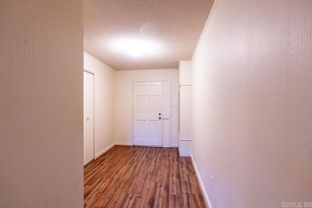713 N Spring St, Searcy, AR 72143 - hallway with wood finished floors, a textured ceiling, and baseboards
