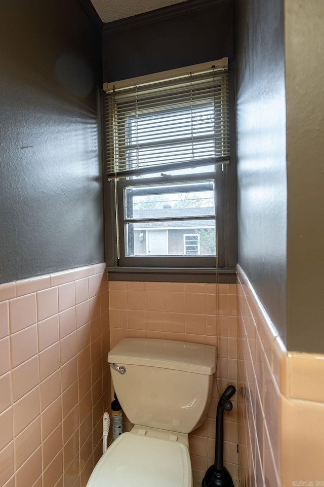 713 N Spring St, Searcy, AR 72143 - bathroom with tile walls, toilet, and a wainscoted wall