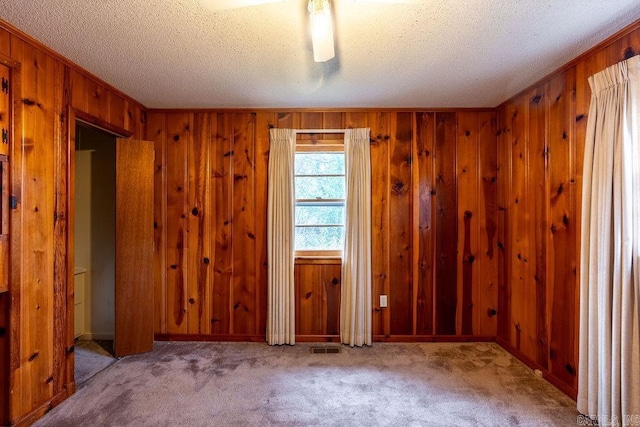 713 N Spring St, Searcy, AR 72143 - carpeted spare room featuring a textured ceiling and wood walls