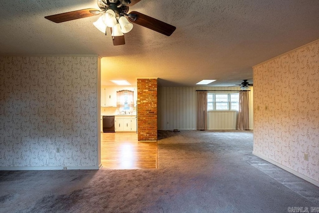713 N Spring St, Searcy, AR 72143 - carpeted spare room with a textured ceiling, a ceiling fan, wallpapered walls, a skylight, and a sink
