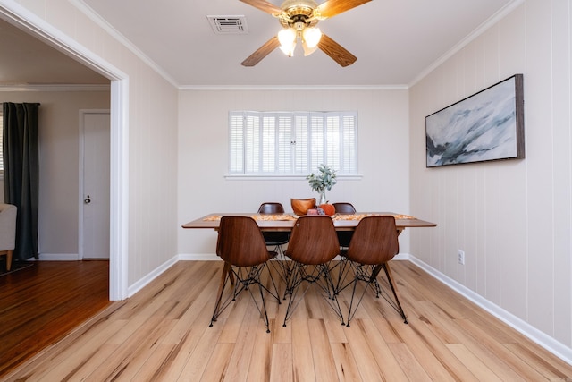 dining area featuring light wood-type flooring, ceiling fan, and ornamental molding