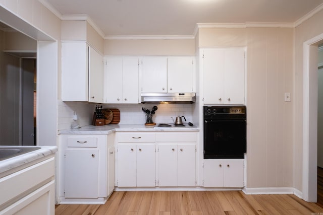 kitchen featuring white cabinets, light hardwood / wood-style floors, black oven, and tasteful backsplash