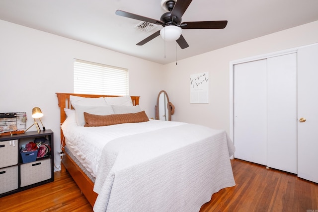 bedroom with a closet, ceiling fan, and dark wood-type flooring