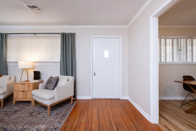 foyer with hardwood / wood-style flooring and crown molding