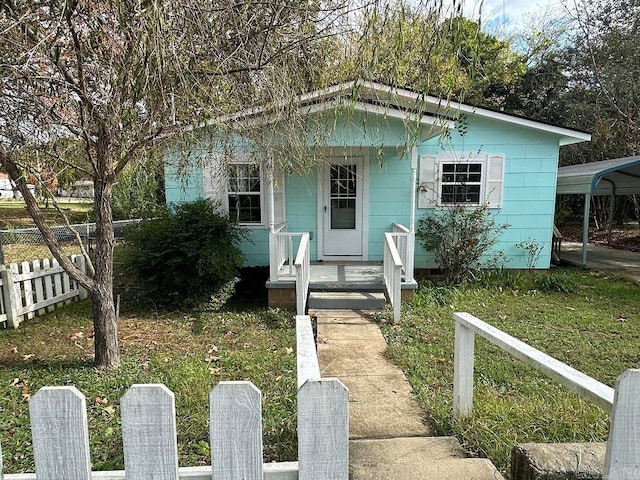 bungalow-style home featuring a carport, a porch, and a front lawn