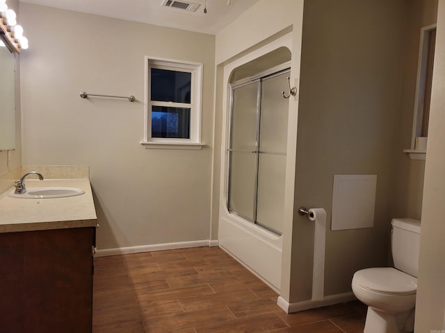 full bathroom with hardwood / wood-style flooring, vanity, toilet, and enclosed tub / shower combo