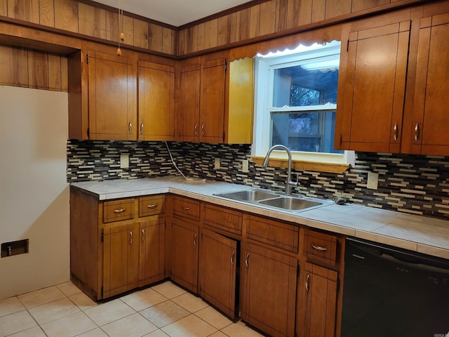 kitchen featuring dishwasher, backsplash, sink, light tile patterned floors, and tile counters