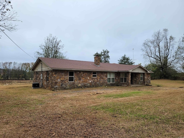 rear view of property featuring cooling unit and a yard