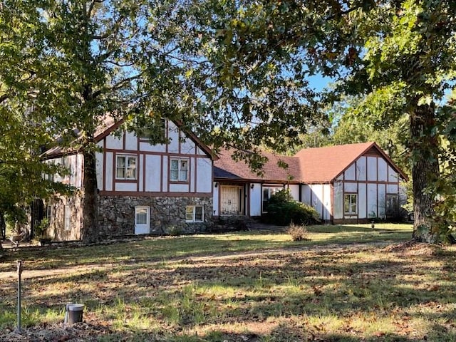 tudor-style house featuring a front lawn