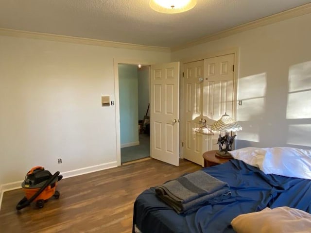 bedroom with a textured ceiling, crown molding, a closet, and dark wood-type flooring