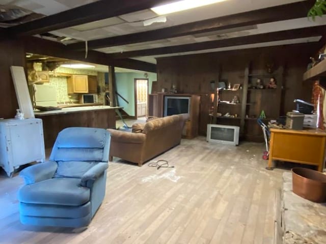 living room with beam ceiling, light hardwood / wood-style floors, and wood walls