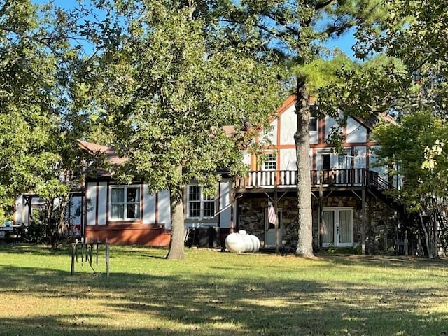 rear view of house with a yard and a deck