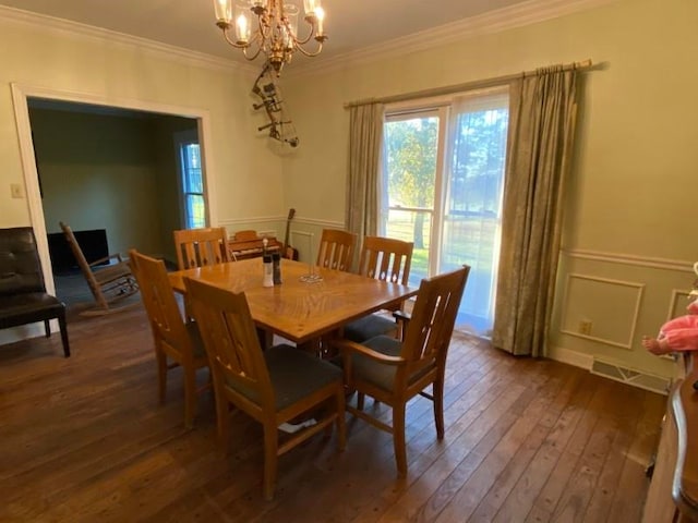 dining space with a notable chandelier, dark hardwood / wood-style floors, and ornamental molding