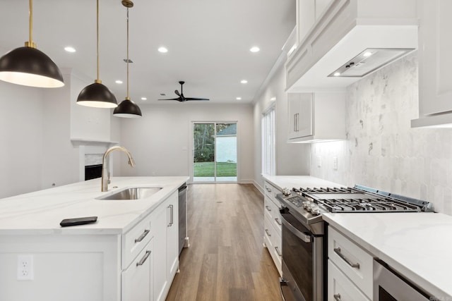 kitchen with white cabinets, sink, ceiling fan, appliances with stainless steel finishes, and decorative light fixtures