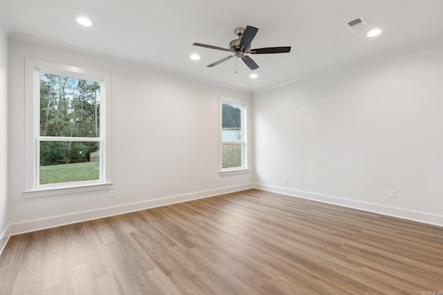 empty room featuring ceiling fan, light hardwood / wood-style floors, and crown molding