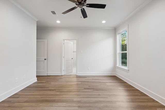 spare room featuring hardwood / wood-style flooring, ceiling fan, and crown molding