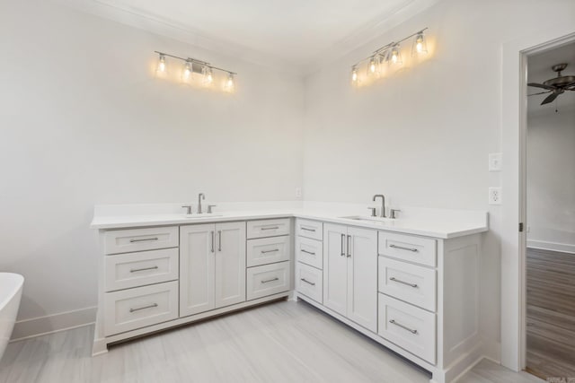 bathroom with a washtub, hardwood / wood-style floors, vanity, and ceiling fan