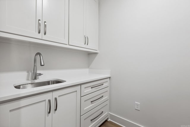 interior space with white cabinetry and sink