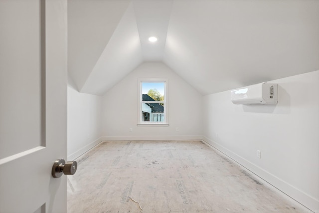 additional living space featuring lofted ceiling and a wall mounted air conditioner