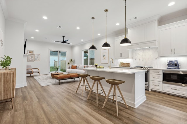 kitchen with appliances with stainless steel finishes, light hardwood / wood-style flooring, and white cabinetry