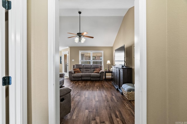 living room with ceiling fan, lofted ceiling, and dark wood-type flooring