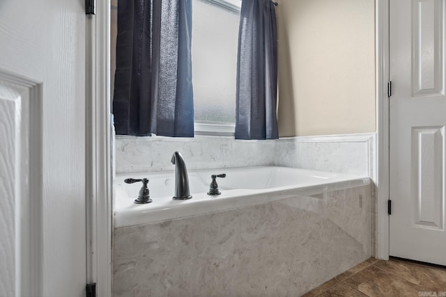 bathroom with a relaxing tiled tub and tile patterned floors