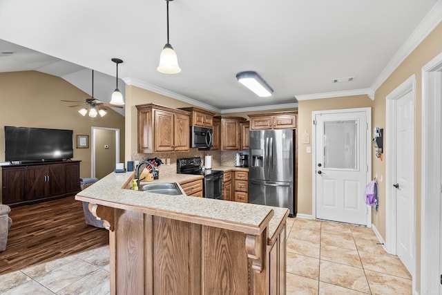 kitchen featuring kitchen peninsula, appliances with stainless steel finishes, a kitchen bar, ornamental molding, and sink