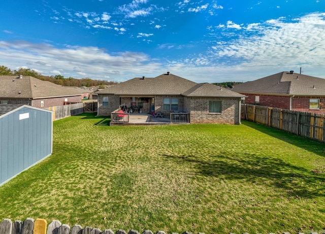 back of house with a patio area, a yard, and a shed