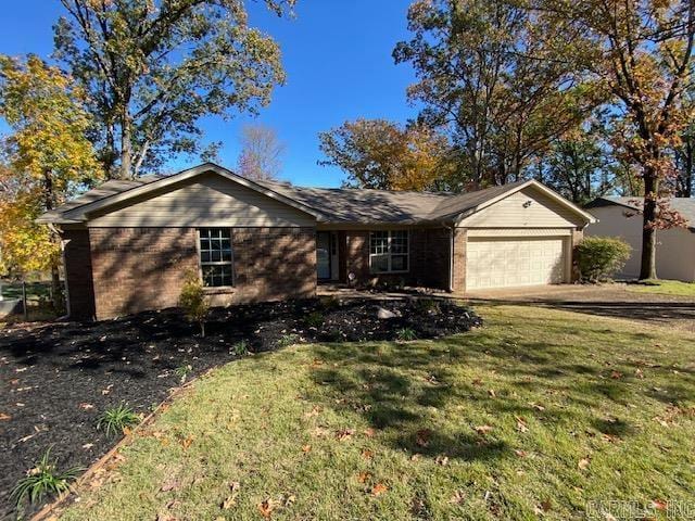 ranch-style home with a garage and a front lawn